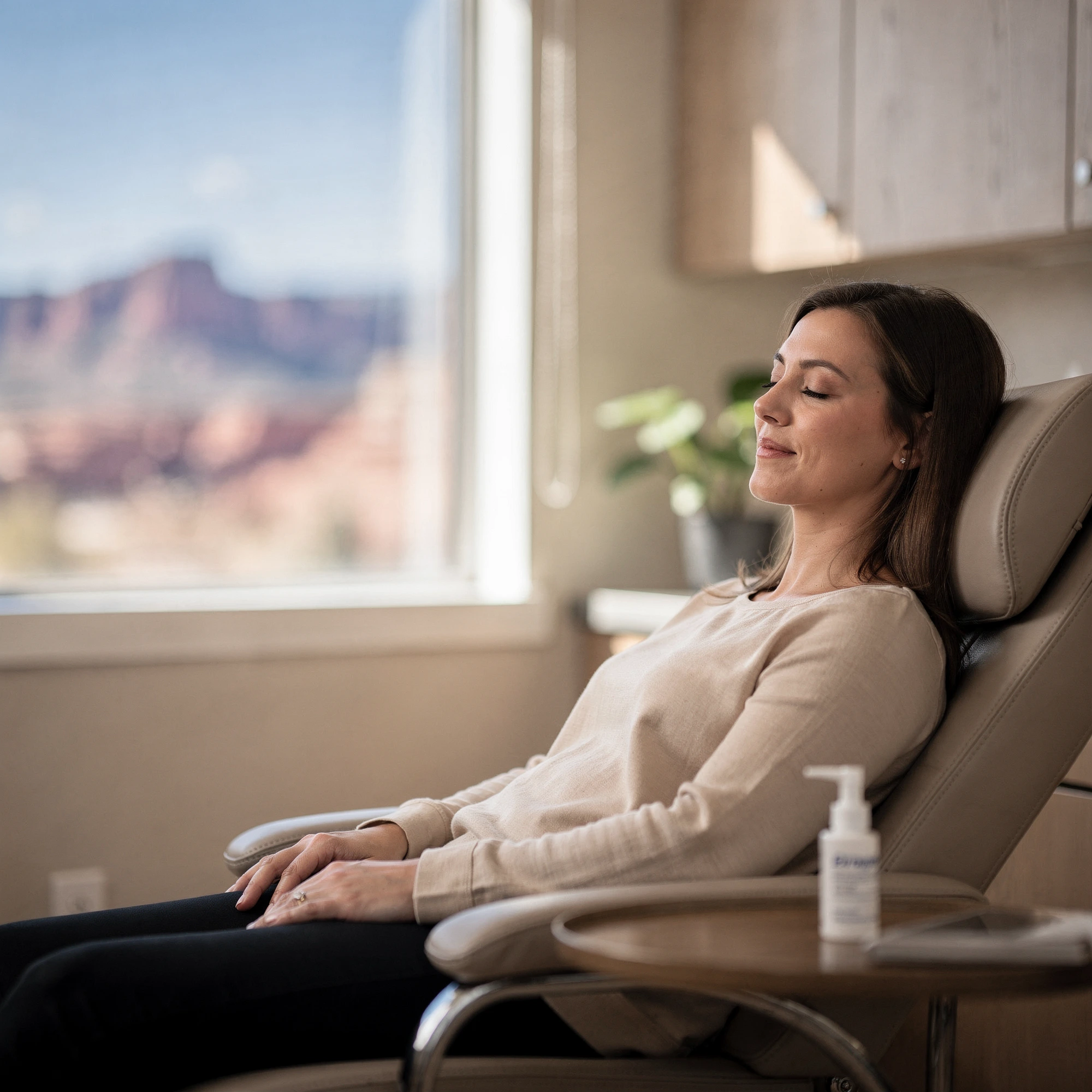 Patient resting in a comfortable chair during Spravato treatment with a mountain view visible through the window